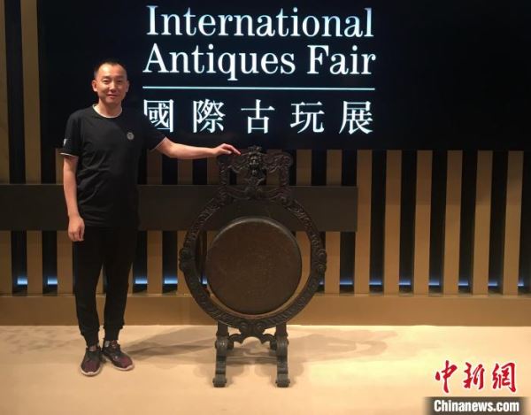 王亮在一年一度的香港国际古玩展拍照留念。王亮供图