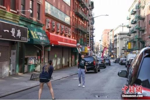 疫情下的纽约唐人街，受新冠肺炎疫情影响，平日喧嚣的纽约曼哈顿唐人街车辆稀少，仍有年轻人在街头运动。(<a target='_blank' href='http://www.chinanews.com/'>中新社</a>记者 廖攀 摄)