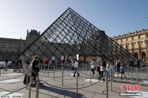 当地时间7月6日，据法新社报道，巴黎卢浮宫在闭馆了近4个月后重新开放，但受新冠疫情影响，部分区域仍向游客关闭。图为游客在卢浮宫博物馆门口排长队等待。