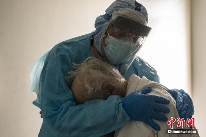 当地时间2020年11月26日，美国休斯敦，联合纪念医疗中心的医生约瑟夫·瓦龙在感恩节期间拥抱并安慰新冠肺炎重症监护室(ICU)的一名患者。图片来源：视觉中国