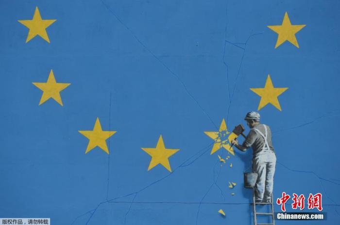 资料图：英国涂鸦艺术家班克西创作了一幅画，画面中一名工人正从欧盟12星旗帜上抹掉一颗星，寓意着英国将脱离欧盟。