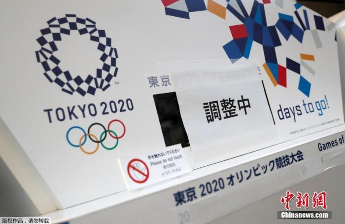 受新冠疫情影响，2020年东京奥运会推迟至2021年夏天举行。图为日本东京中央区，一原本显示东京奥运会倒计时的电子屏被贴上了“正在调整”的字样，下方奥运会的原定举办日期也被遮挡了起来。