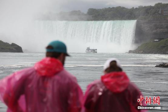 资料图：加拿大游客乘船游览加拿大、美国交界处的著名景点尼亚加拉大瀑布。<a target='_blank' href='http://www.chinanews.com/'>中新社</a>记者 余瑞冬 摄