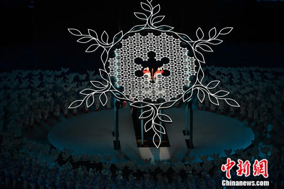 2022年2月4日晚，第二十四届冬季奥林匹克运动会开幕式在北京国家体育场举行。图为最后一棒火炬手迪妮格尔·衣拉木江(左)和赵嘉文将火炬嵌入“大雪花”中央。<a target='_blank' href='http://www.chinanews.com/'>中新社</a>记者 毛建军 摄