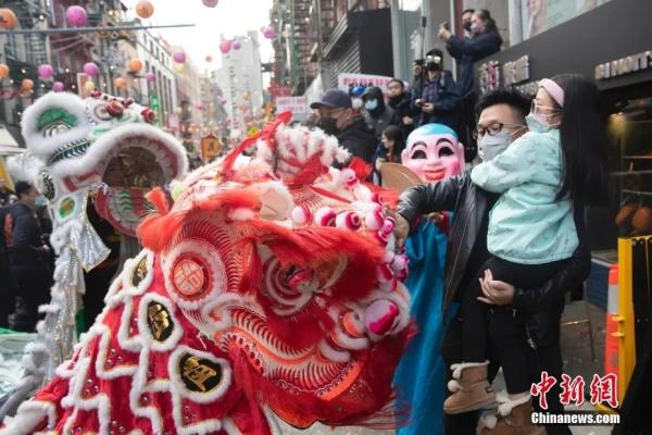 2月12日，美国纽约曼哈顿唐人街举行春节庆祝活动，民众聚集唐人街欢庆新春。图为一位父亲带着女儿触摸舞狮。 <a target='_blank' href='http://www.chinanews.com/'>中新社</a>记者 廖攀 摄