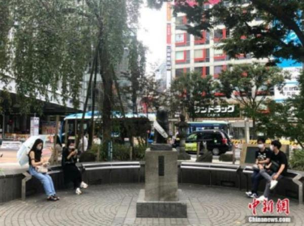 资料图：日本民众在涩谷车站前的雕塑旁休息。 <a target='_blank' href='http://www.chinanews.com/'>中新社</a>记者 吕少威 摄