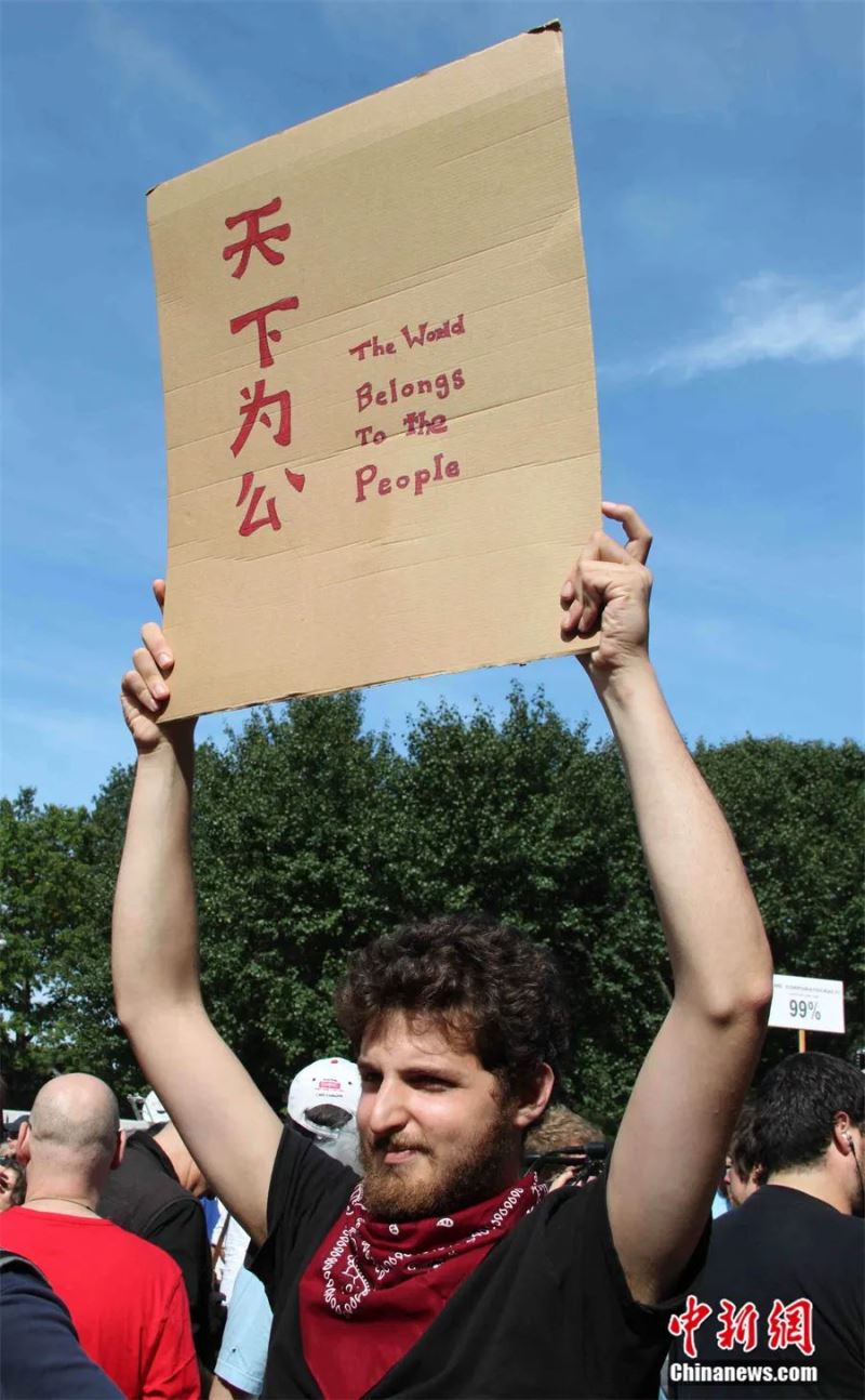 2011年，“占领华尔街”示威者高举“天下为公”标语。<a target='_blank' href='http://www.chinanews.com/'>中新社</a>记者 李洋 摄