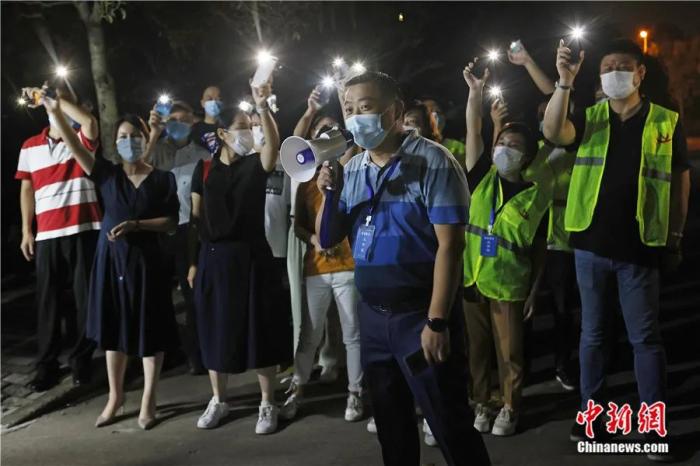 2021年，在上海浦东某小区门口，社区工作者与居民们一起等待疫情解封时刻。<a target='_blank' href='/'>中新社</a>记者 殷立勤 摄