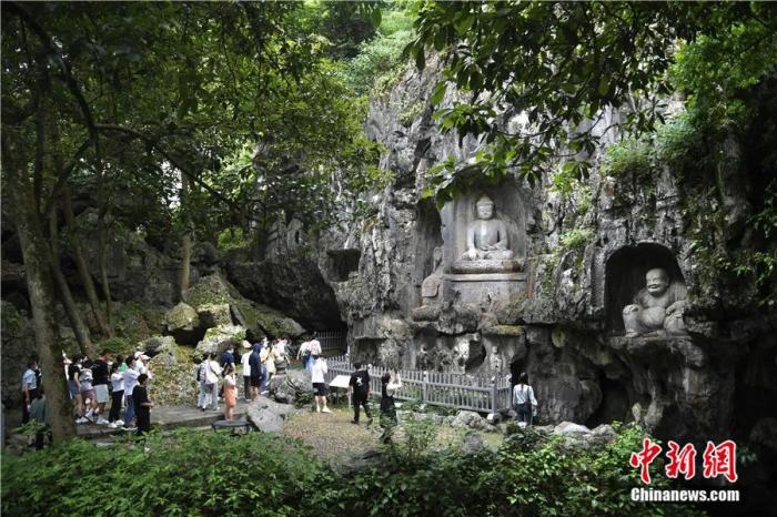 游人在杭州西湖飞来峰景区参观佛像石刻。王刚 摄