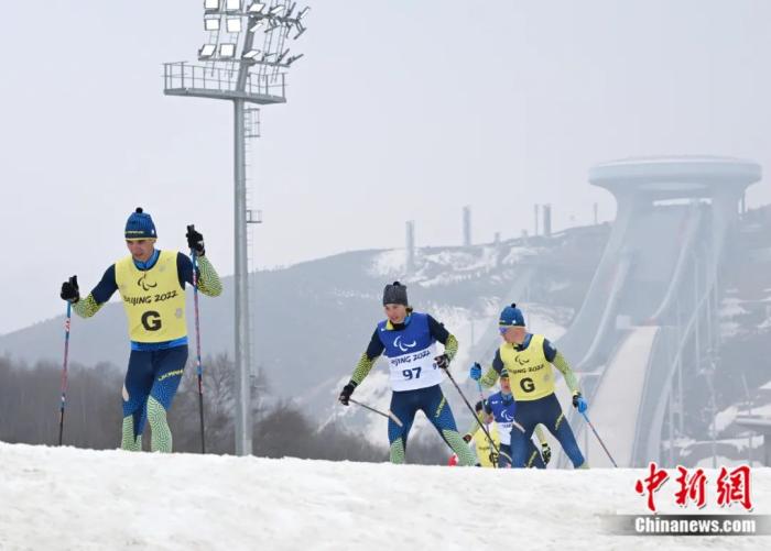 北京2022年冬残奥会残奥冬季两项女子长距离-视障项目决赛上，乌克兰运动员希什科娃(97号)在引导员的带领下经过上坡赛道。侯宇 摄