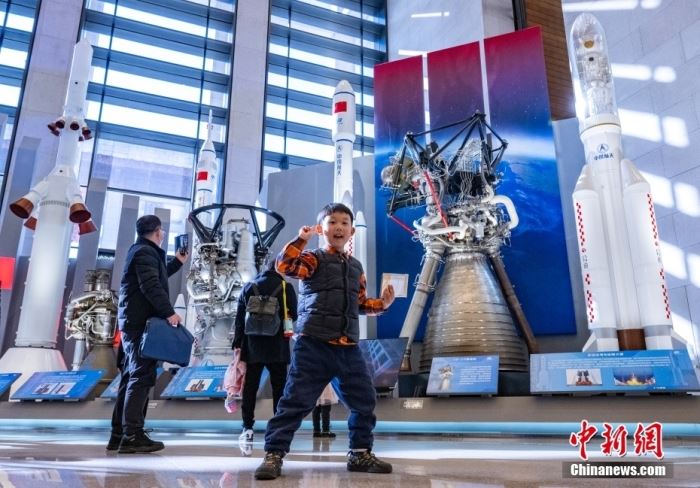 2月24日，“逐梦寰宇问苍穹——中国载人航天工程30年成就展”在位于北京的中国国家博物馆开幕。该展览为期3个月，展示包括可入内参观的中国空间站天和核心舱1:1模型、空间站组合体1:4模型等，并首次展出新一代运载火箭、载人飞船及月面着陆器等未来载人登月主要飞行产品模型，是首次全面系统面向公众展示工程发展历程和建设成就。图为一名小朋友在中国各型运载火箭及火箭发动机模型展品前拍照。<a target='_blank' href='/'>中新社</a>记者 侯宇 摄